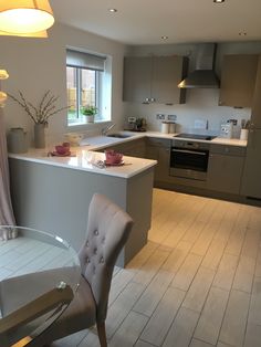 a kitchen and dining room with an open floor plan, white countertops, stainless steel appliances and gray cabinets