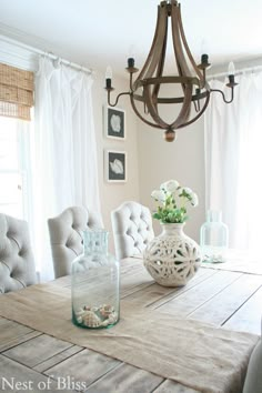 a dining room table with chairs and a vase filled with flowers