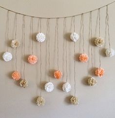 there are many flowers hanging on the wall and some string is attached to the wall