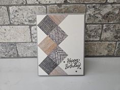 a happy birthday card on a table next to a brick wall