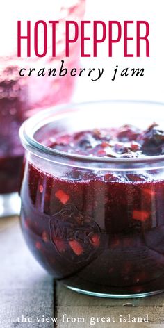 a glass jar filled with cranberry jam sitting on top of a wooden table