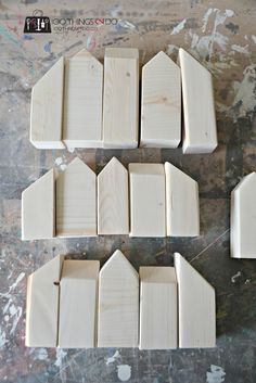 small wooden houses sitting on top of a table next to each other in the process of being made