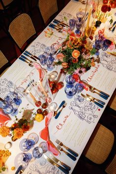 the table is set with colorful dishes and place settings for an elegant dinner or celebration