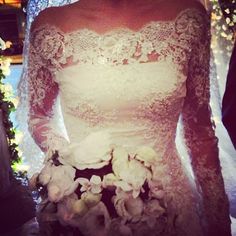 a woman wearing a wedding dress with flowers on it