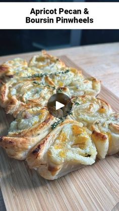 a wooden cutting board topped with a pizza covered in cheese and herbs on top of it