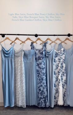 there are many dresses hanging on the clothes rack in front of a sign that says light blue satin, fresh blue jersey dressy cotton slub