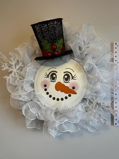 a snowman face with a black top hat on it's head and white net