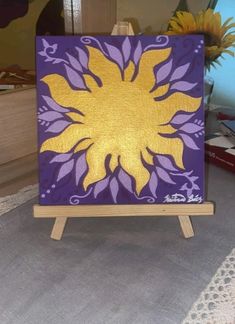 an easel with a painting on it sitting on a table