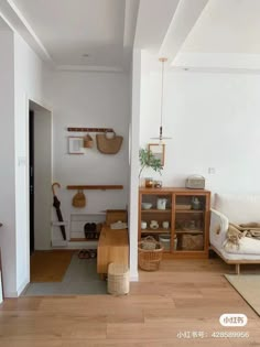 a living room filled with furniture and baskets on the wall next to a doorway that leads to another room