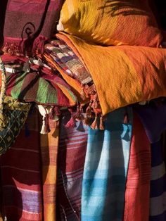 colorful fabrics are hanging from the back of a person's arm, with their arms wrapped around each other