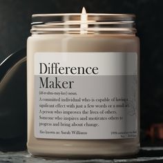 a candle that is sitting on a table next to a jar with some writing on it