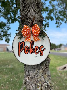 a wooden sign that says pokes hanging on a tree