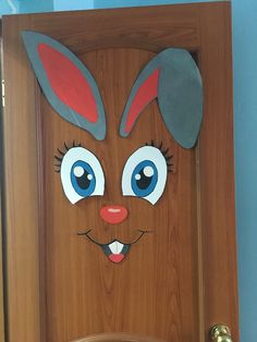 a wooden door decorated with an image of a bunny's head and ears on it