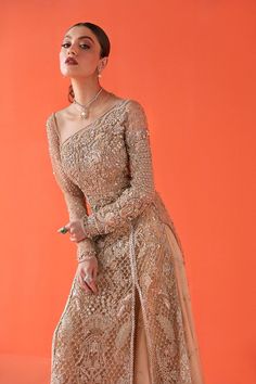 Unique Indian Bridal Golden Skirt Lehenga Dress is The radiance of the color gold and hints of peach are used as the canvas for Asel which is an elongated double-slit shirt, sparkling with crystals and heavily worked details. Comes with flared sharara pants which make a perfect contrast for this contemporary silhouette. This dress can be customized with a net dupatta according to your choice. Kameez: Mughal Inspired Bridal Long Tail Shirt is emblazoned in zardozi with luxurious glitter of Swarov Mysie By Tahira, Golden Skirt, Skirt Lehenga, Lehenga Dress, Sharara Pants, Golden Dress, Bridal Dress Fashion, Indian Bridal Wear, Indian Clothing