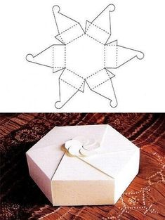 an origami box with scissors and thread on it