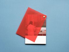 a red and white folder on a blue background with a woman in the mirror behind it