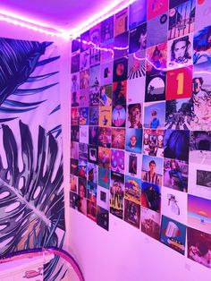 there is a wall with many pictures on it in the room that has purple lighting