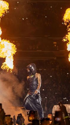 a man standing on top of a stage surrounded by fire