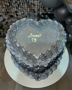 a frosted heart shaped cake sitting on top of a white plate