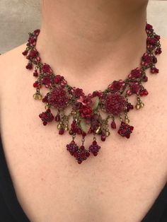 Gorgeous garnet red, bauble necklace with clusters of flowers and red roses. The color is a deep red with just hints of olive green.  There are 5 small hand made baubles that hang in the front  Intricate beading continues all the way around the neck with seed beads and small flower beads. Hand beaded with glass bead and hand painted resin flowers.  Simply stunning necklace and so pretty with anything black.   This is a quality piece of jewelry that will last a life time. Created by designer Coll Custom Headbands, Red Tea, Tea Rose, Funky Jewelry, Green Accents, Choker Necklaces, Stunning Necklace, Jewelry Designer, Dream Jewelry