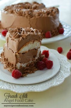 two pieces of chocolate cake on plates with raspberries