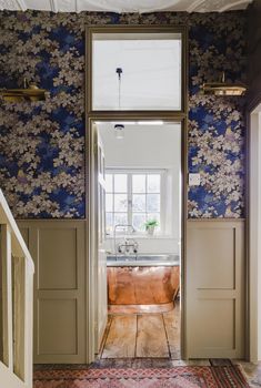 an open door leading to a bathroom with floral wallpaper