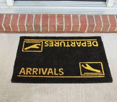 a black door mat with yellow arrows and an arrow pointing to the left that says arrivals