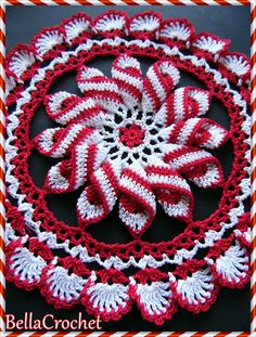 a crocheted red and white doily with candy canes in the center