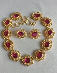 Classic art deco style necklace and earrings set made using Synthetic Ruby ovals shape cut stones and base metal used is guaranteed pure silver 925 and is real gold 22K filled which is very durable and will stay for years. Ruby Ovals are of 10 mm x 12 mm Gold Filling is completely different from Gold Plating as gold filling contains 100% gold which does not go away easily and enhances the life and look of the jewelry. Elegant 22k Gold Oval Jewelry, Formal Gold Oval Jewelry Set, Formal Oval Gold Jewelry Set, Gold Oval Temple Jewelry, Oval Temple Jewelry For Formal Occasions, Formal Gold Jewelry Sets With Gemstones, Festive Oval Hallmarked Jewelry, Gold Ruby Necklaces With Matching Earrings, Oval Necklace