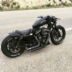 a black motorcycle is parked on the side of the road