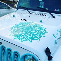 a white jeep with a green flower decal on the hood