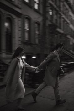 two people walking down the street holding hands