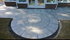 a circular stone patio with glass doors and windows