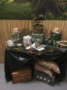 a table with many items on it in front of a bamboo wall and tree mural