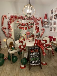 a room decorated for christmas with candy canes and elf decorations on the wall, around a table