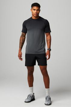 a man in black shorts and grey shirt