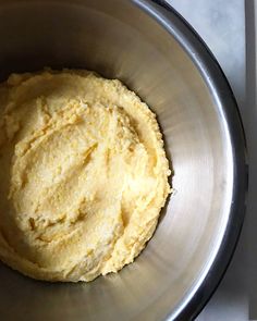 a metal bowl filled with dough on top of a counter