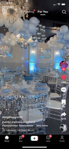 a room filled with lots of white balloons and tables covered in silver table cloths