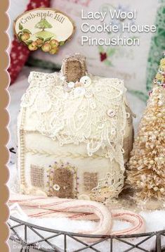 a miniature house sitting on top of a table next to a christmas tree and candy cane