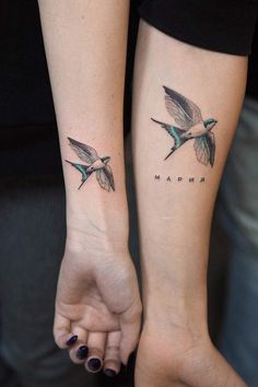 two small tattoos on the arms of people with hummings flying above their heads and below them