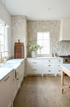 a kitchen with white cabinets and wood floors