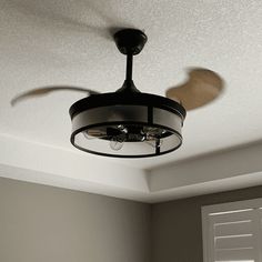 a ceiling fan is hanging from the ceiling in a room with gray walls and white trim