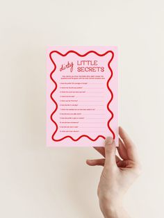 a person holding up a pink card with the words dirty little secrets written on it