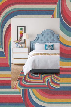 a bedroom with colorful stripes on the wall and bed in the center, along with a dresser