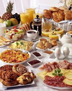 a table filled with lots of different types of breakfast foods and condiments on it