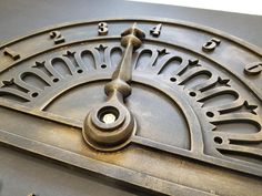 an old metal clock with roman numerals on it