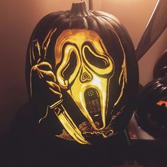 a carved pumpkin with an image of a person holding a knife and wearing a mask