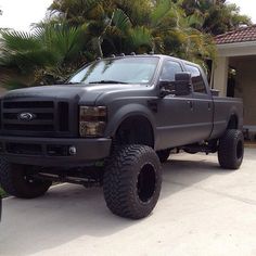 a black truck parked in front of a house