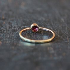 A gorgeous, rose-hued Rhodolite Garnet gemstone is handset entirely in 14k yellow gold. The bezel that holds the garnet stone is integrated right into the band, which I hammer for a sparkling, faceted finish. Rhodolite garnet has a much more raspberry tone than traditional garnet, and it is absolutely stunning paired with yellow gold. The gold I use is recycled and refined in the U.S. by an award-winning facility. This ring is made to order for you in your requested ring size. The garnet gemston Fine Jewelry Garnet Ruby Ring With Bezel Setting, 14k Gold Ruby Ring With Bezel Setting, 14k Rose Gold Ruby Birthstone Ring, Rose Gold 14k Ruby Birthstone Ring, Garnet Birthstone Ring In Yellow Gold, Pink Gold 14k Ruby Ring, Tourmaline Birthstone Ring With Bezel Setting, Gold Tourmaline Birthstone Promise Ring, Birthstone Ring In 14k Rose Gold With Gemstone