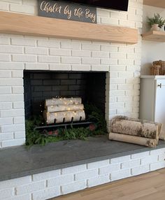 a white brick fireplace with christmas decorations on it and a sign above the fire place